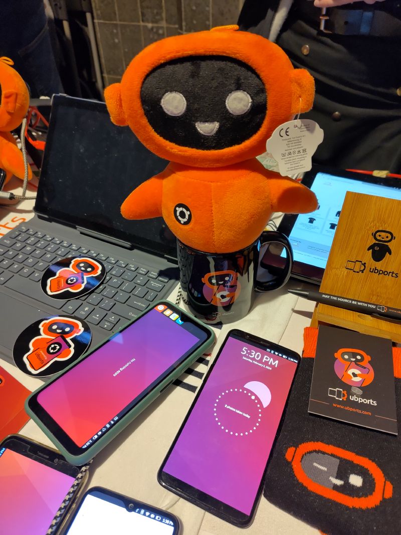 Ubuntu Touch mascot looking over the phones.