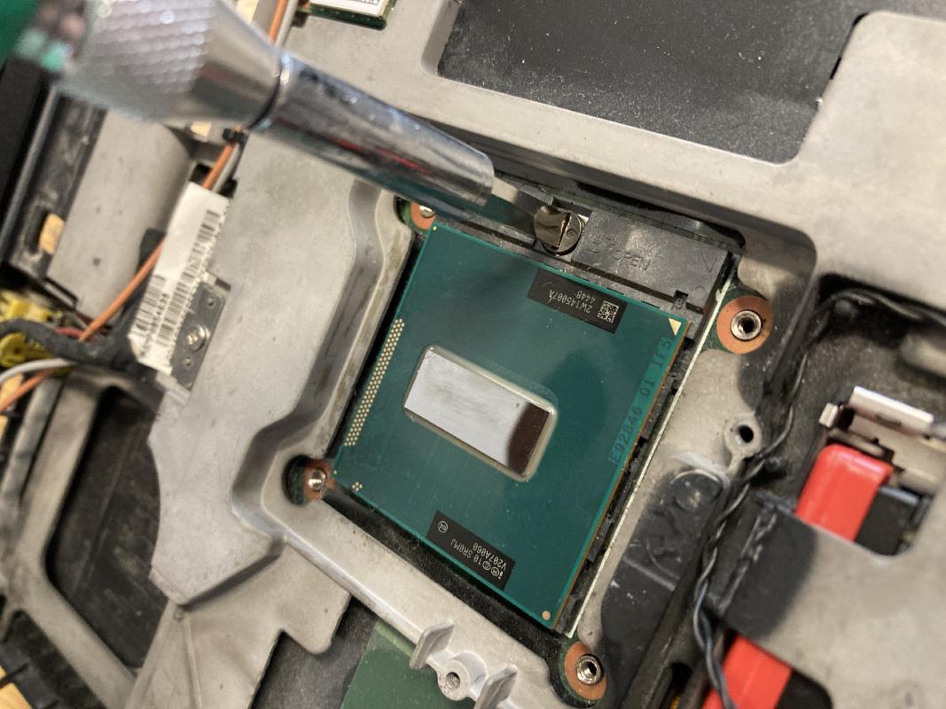 Loosen the CPU by turning the screw with a flathead screwdriver.