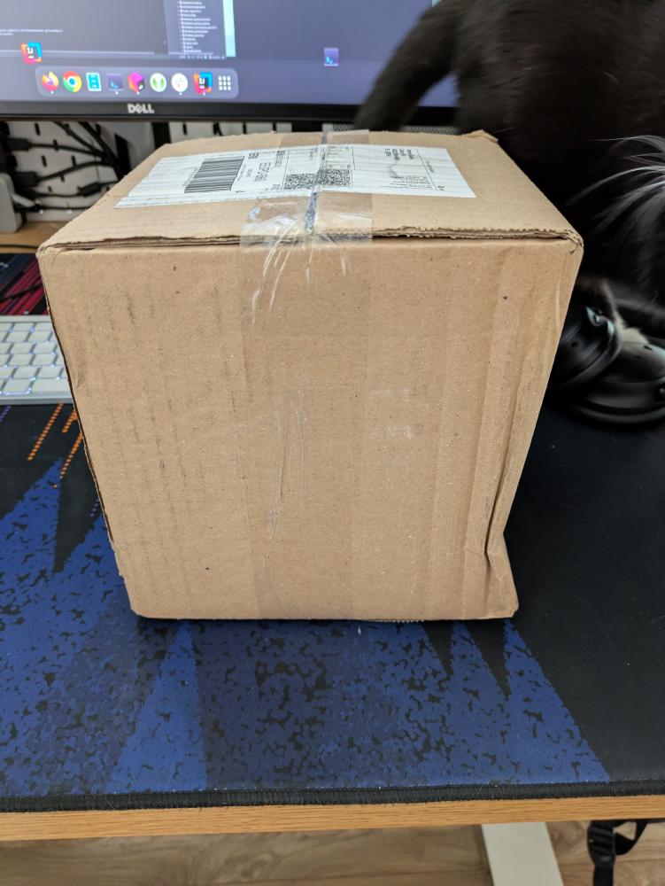 The cardboard box with a slight dent.